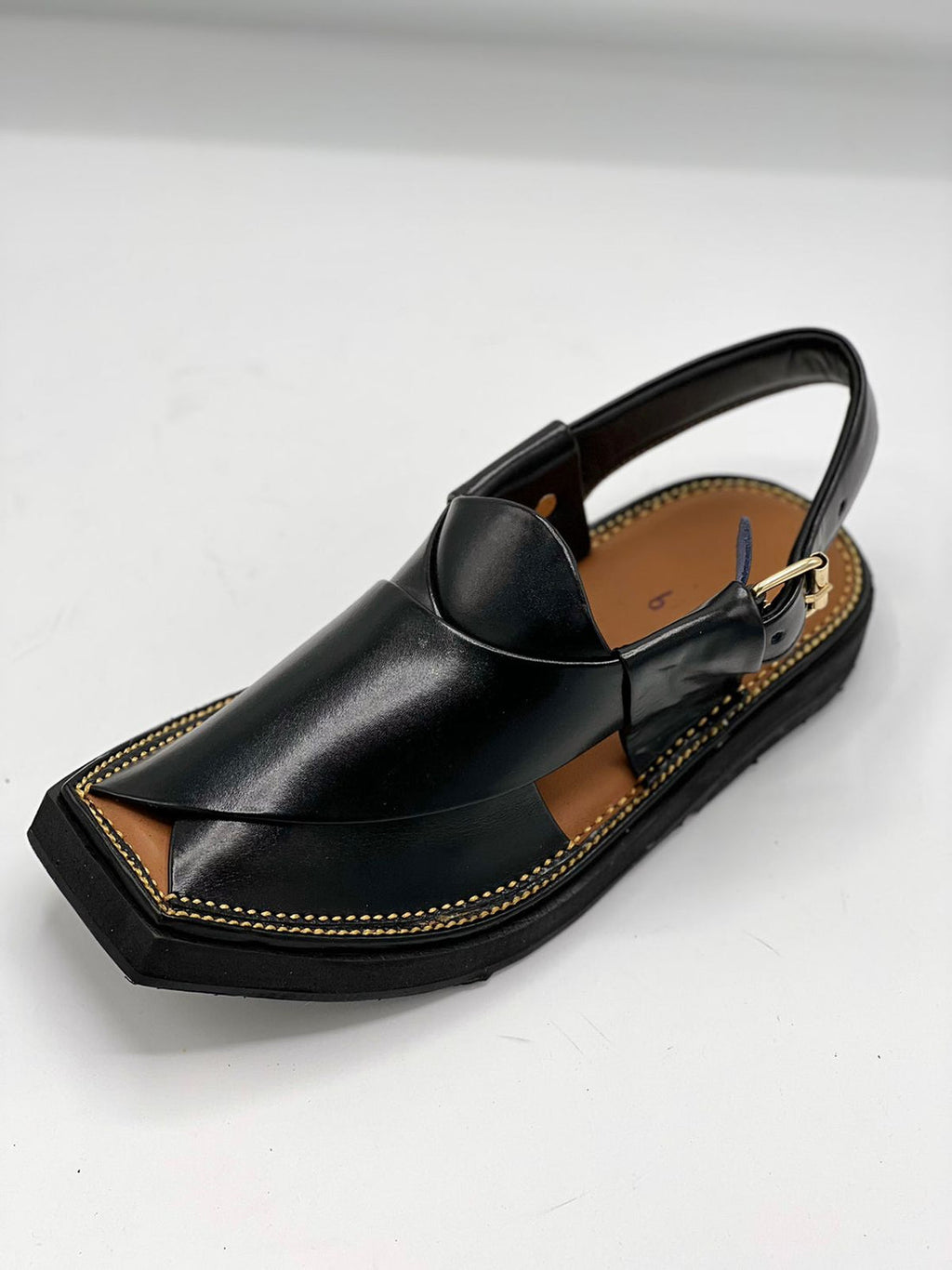 Black sandal with a unique design on a white background