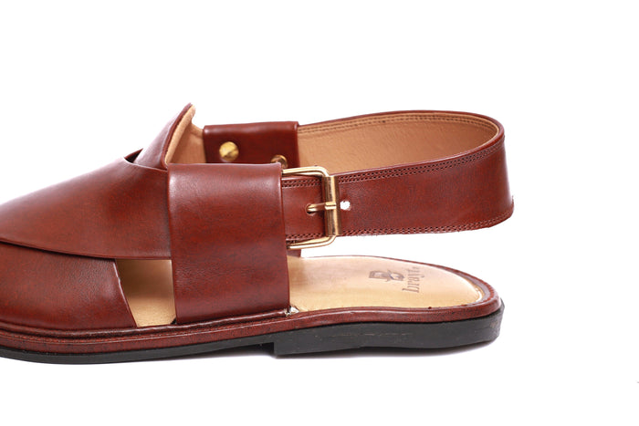 Brown sandal with a strap and buckle on a white background