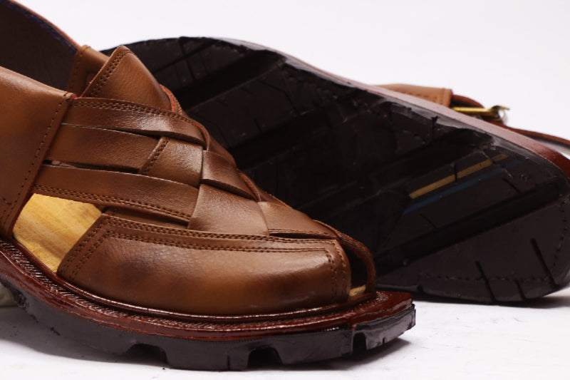 Brown leather sandal with woven straps on a white background